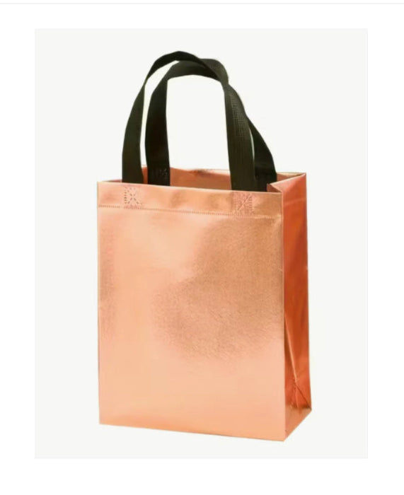 Rose gold tote bag with black handles on a white background